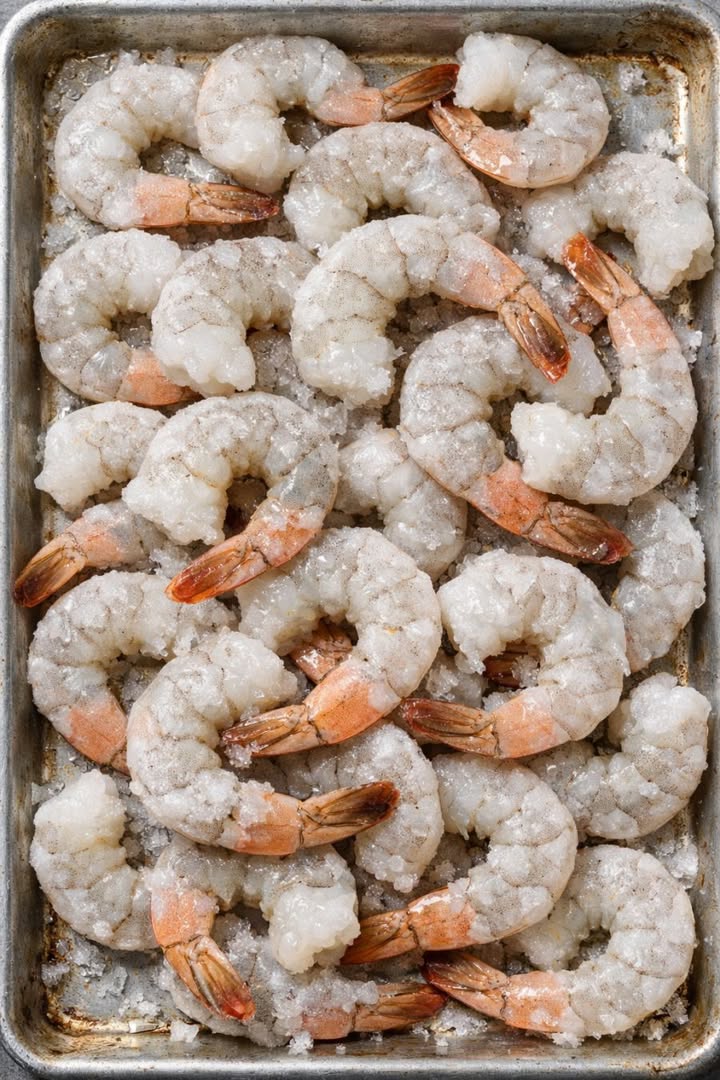 Put a bag of frozen raw shrimp onto a sheet pan and 2 simple additions to get a spring dinner so mouthwatering your friends will be begging for the re